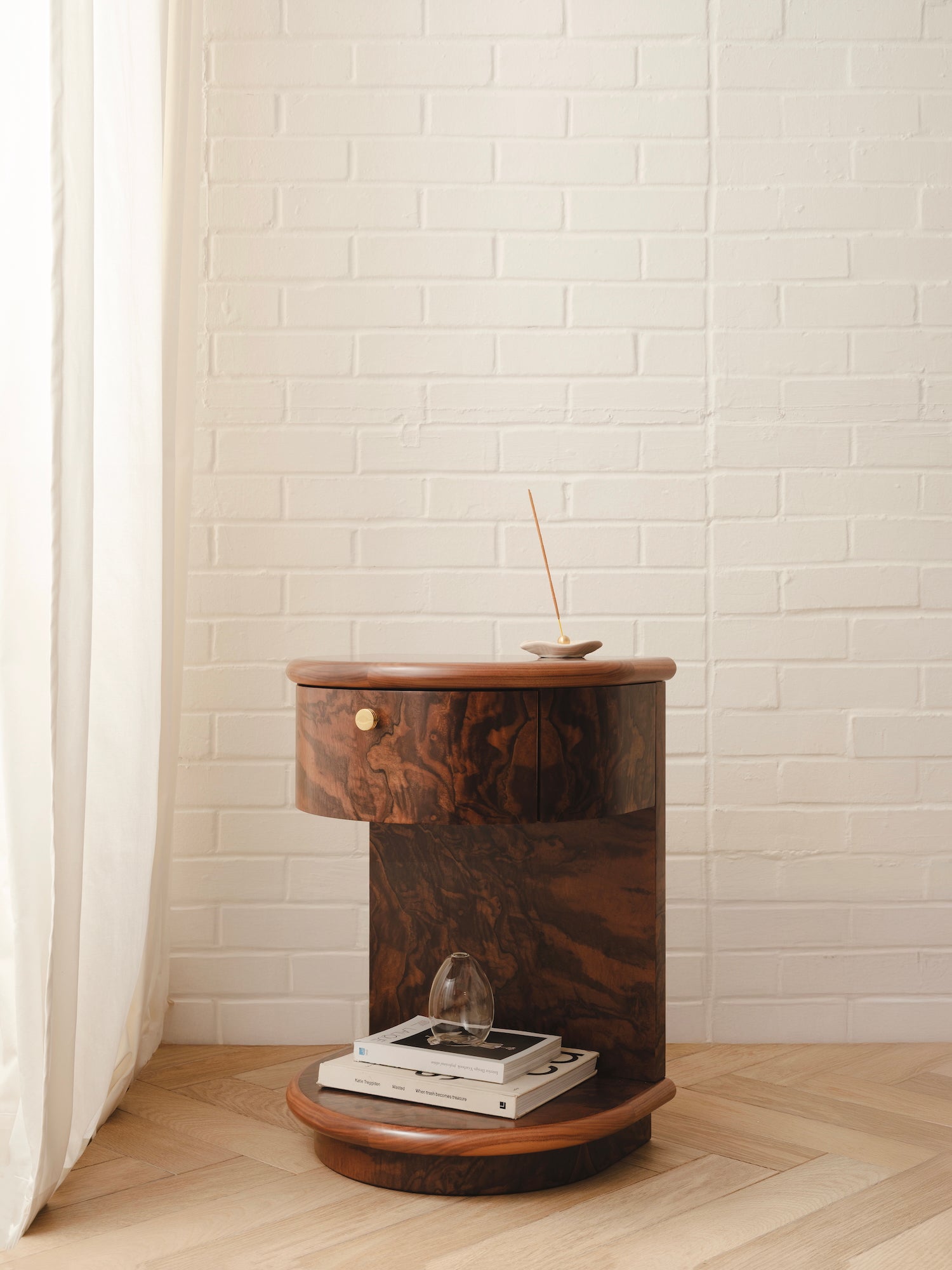 Wooden side table with a single drawer and a brass handle. In a burr finish.